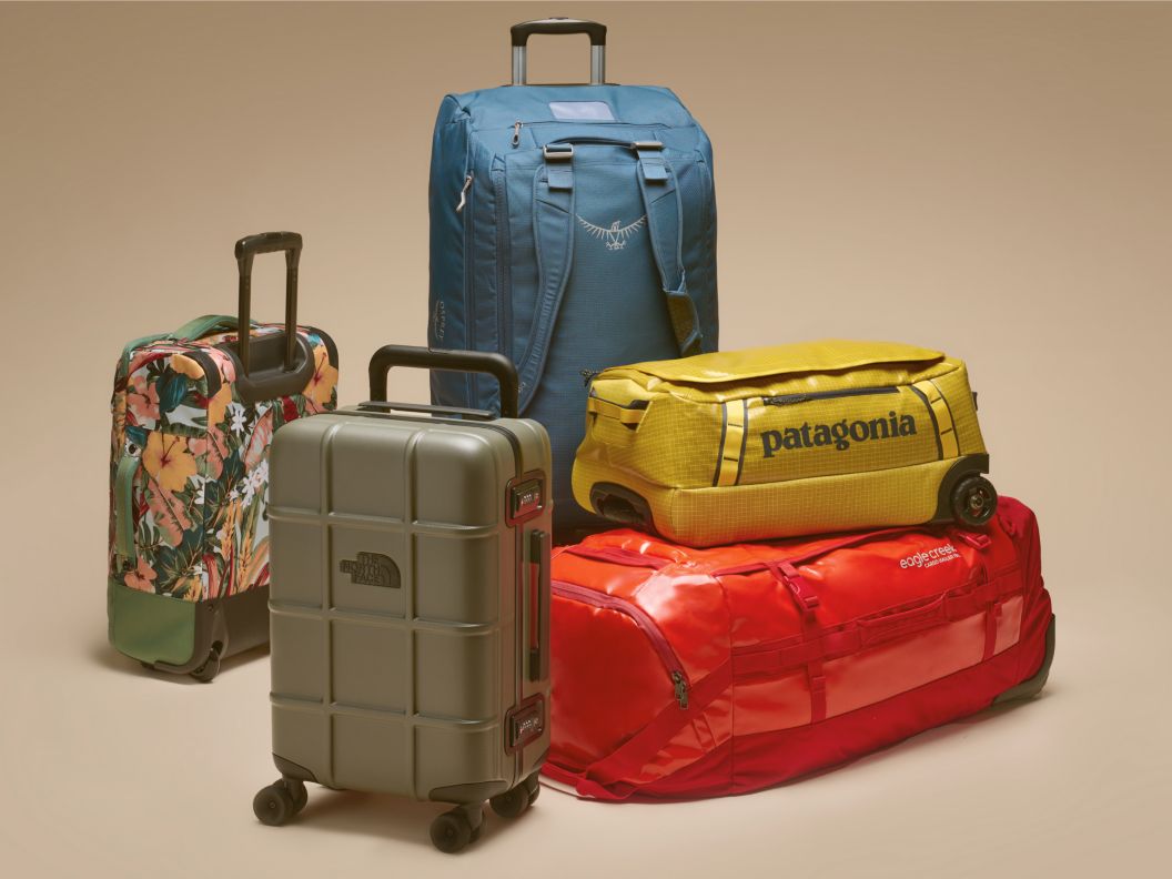 A collage of lifestyle photography surrounded by a collection of brightly colored travel bags including rollers and duffels.