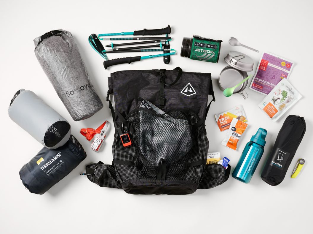 Backpacking gear spread across white background. 