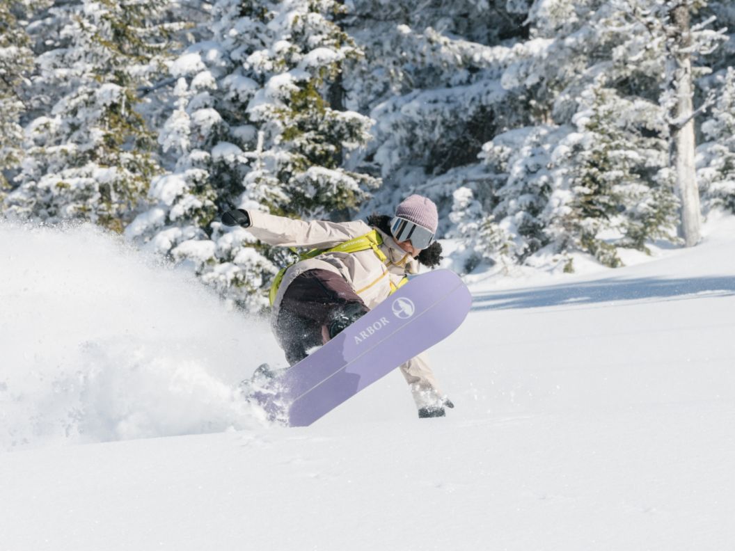 Snowboarder slashing an epic powder turn. 