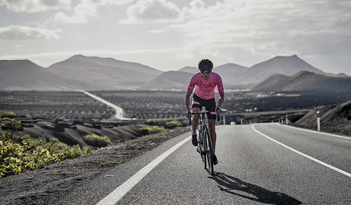 Girl with pink castelli jersey riding bike uphill