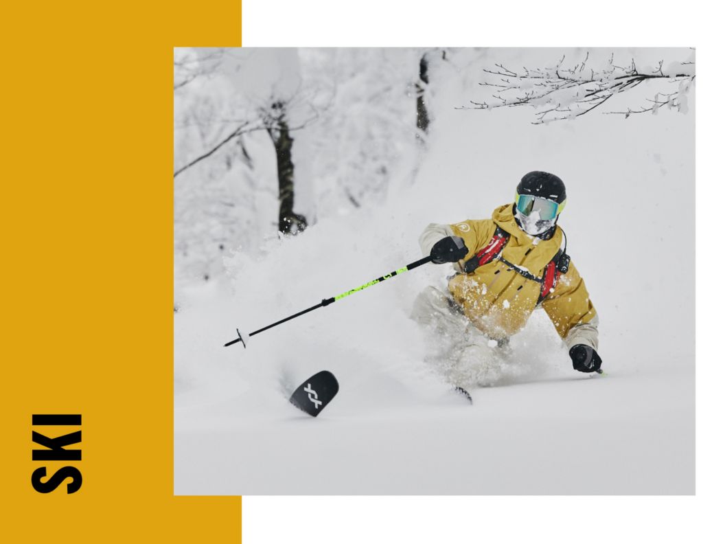 A person skiing in a yellow jacket. 