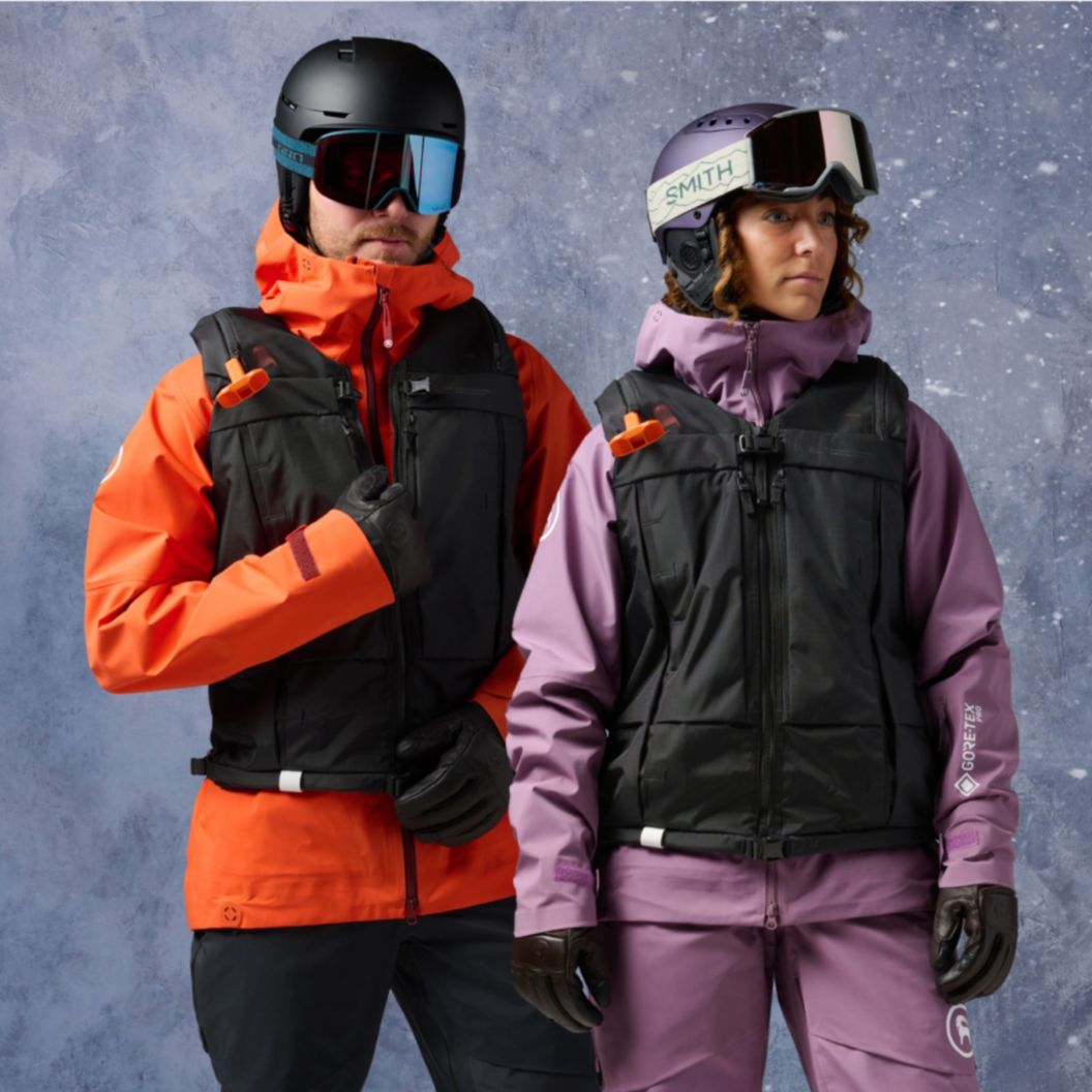   A man and woman wear the Db x Safeback avalanche safety vest.  