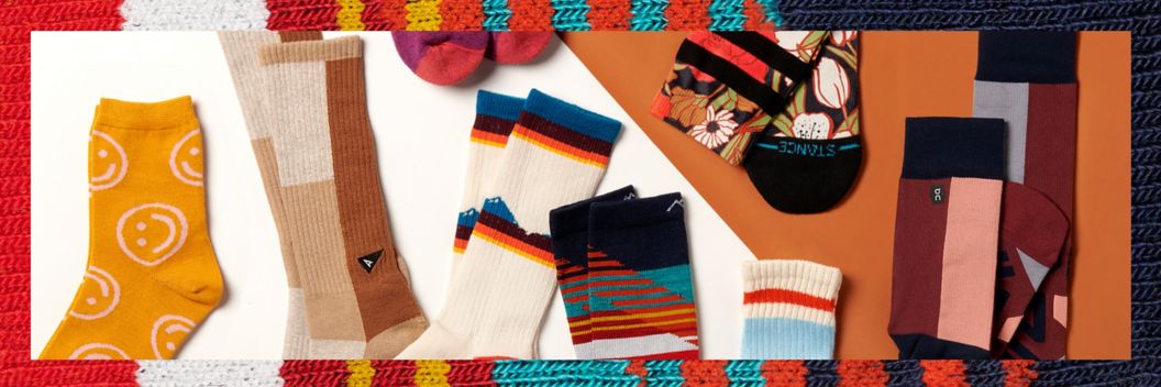 Assorted socks with colorful designs lying on a flat surface.
