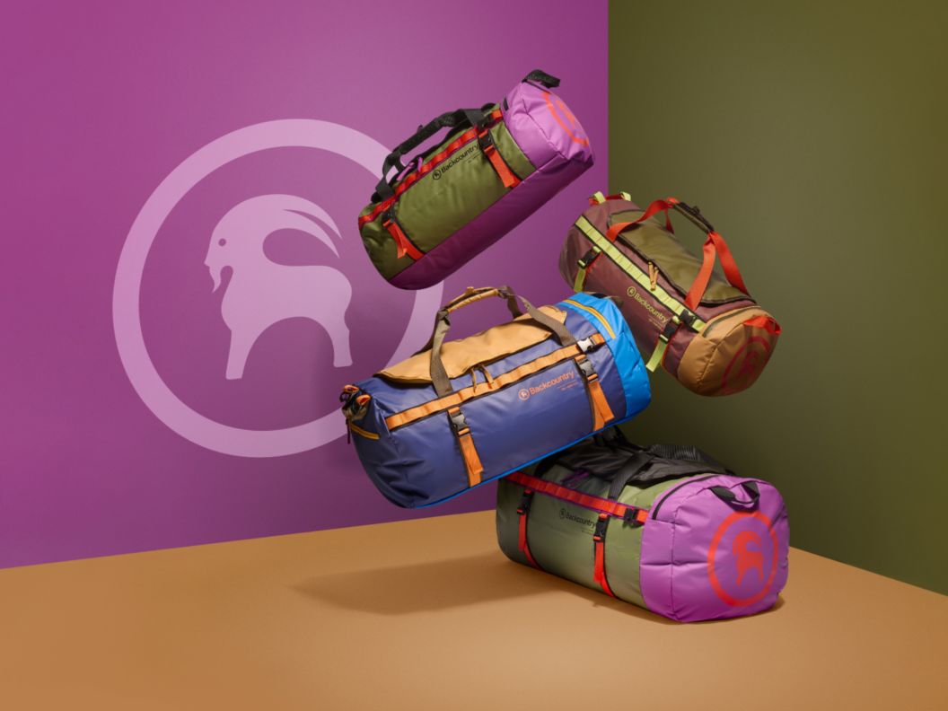 Four colorful duffel bags float before a color-blocked wall
