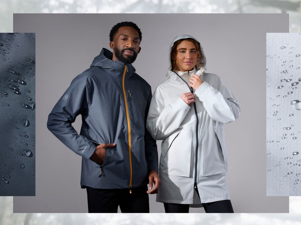 Two models wearing the grey and white colors of the Runoff Rain jacket, with close-up imagery of water beads on the jacket material on the edges of the image.