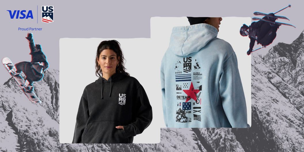 Two models show off new U.S. Ski & Snowboard hoodies. The upper right-hand corner shows off the teams’ logo along with their sponsor, VISA.