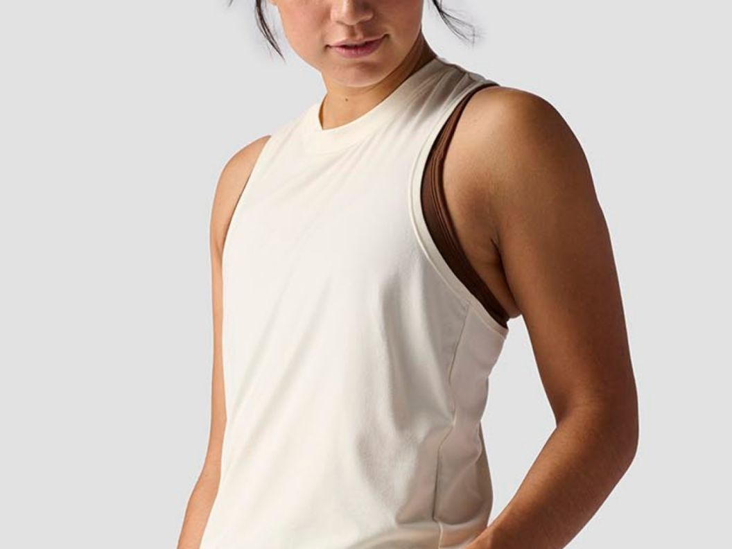 A woman wearing an off-white-colored tank top.