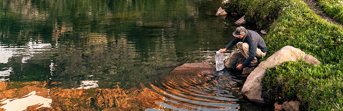 A man fills up the Platypus GravityWorks reservoir in a lake.
