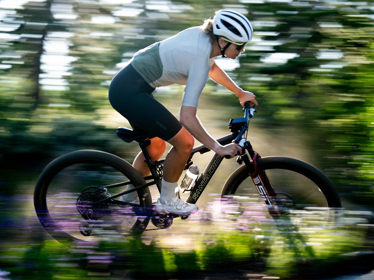 Biker riding fast down mountain trail.