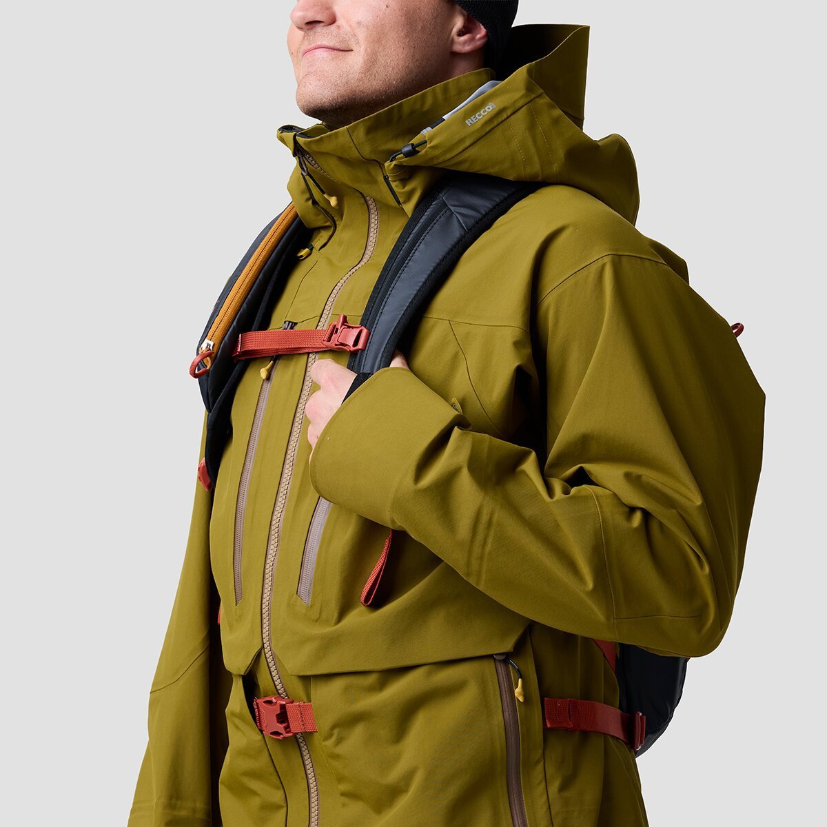 Person wearing Cottonwoods ski jacket with touring backpack with waist belt threaded through strap tunnel and buckled in front.