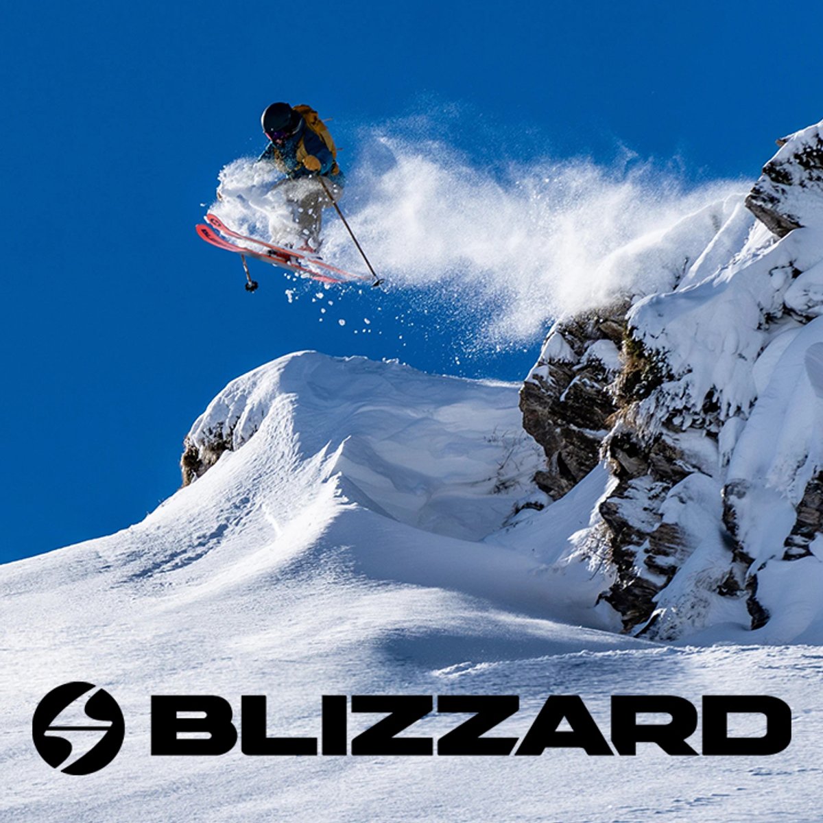 Skier jumping off snowy cliff with Blizzard skis in alpine terrain with Blizzard logo