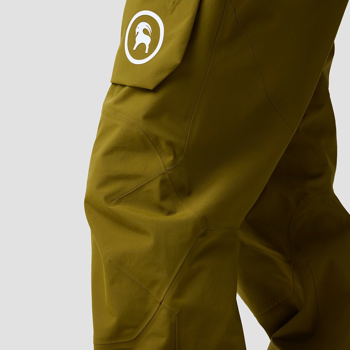 Close up of knee-area of person wearing Cottonwoods bibs showing construction details with articulated knee seams curve.