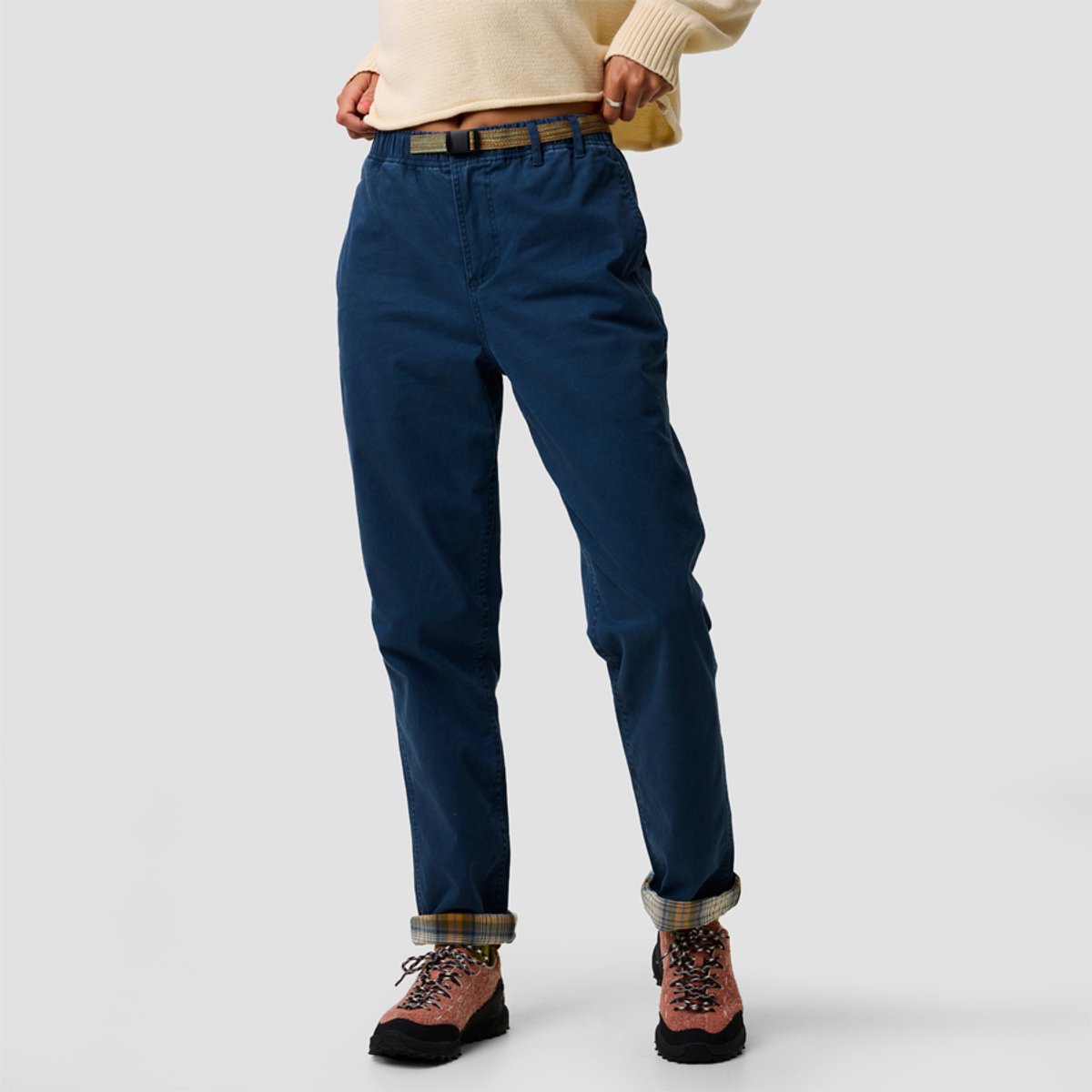 A woman wears the BGA Venture Daily Flannel-Lined Pant, styled with a cream sweater and hiking boots.