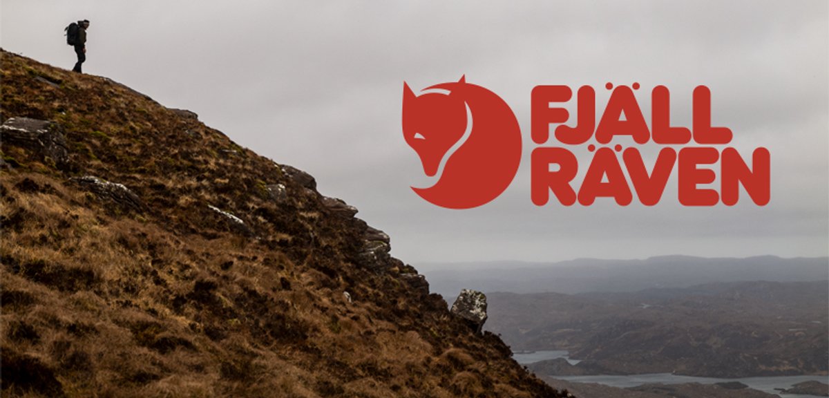 A man stands on a rocky outcropping, overlooking a cloudy valley. The Fjallraven logo is featured prominently in the corner.