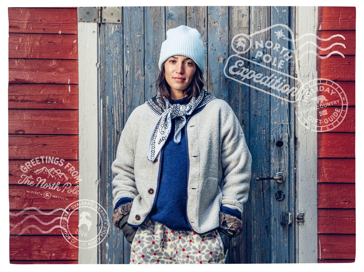 Person in a beanie, bandana, and sherpa fleece jacket standing against a weathered wooden door, with “Greetings from the North Pole” stamp.