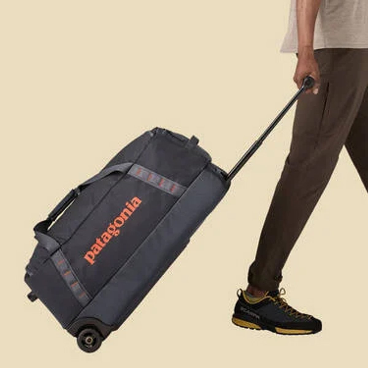 A person pulls a Black Hole Wheeled Duffel 70L behind them.