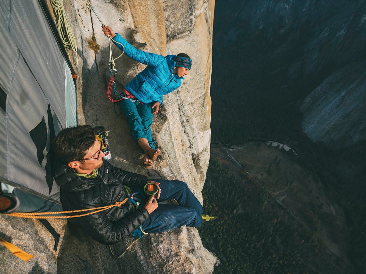 Two climbers sitting on cliff edge.