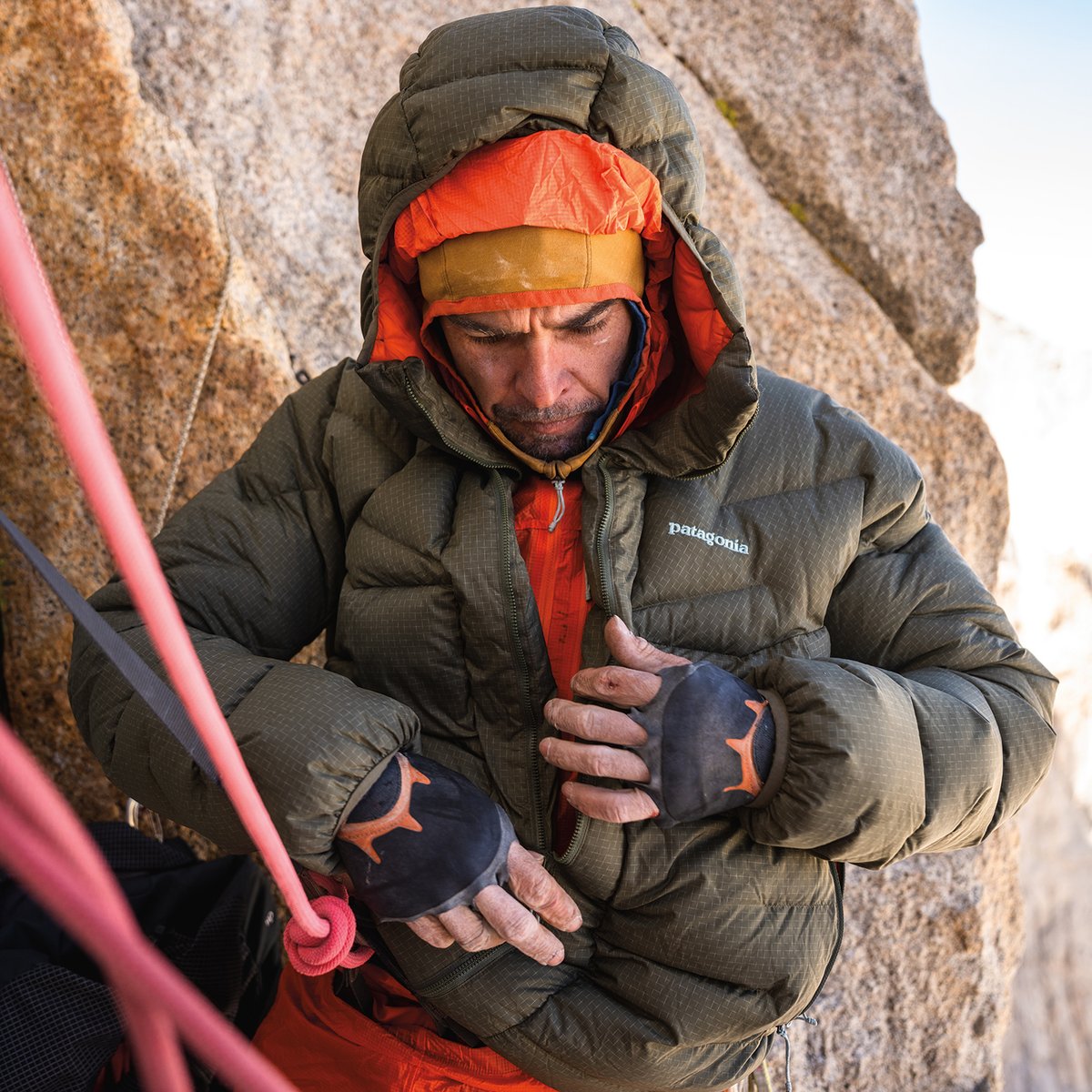 Puffy jacket unzipped with belay loop sticking out and clipped in.