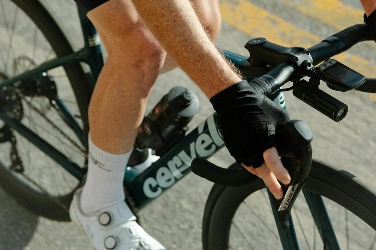 Cyclist’s hands on drop handlebars of a road bike.
