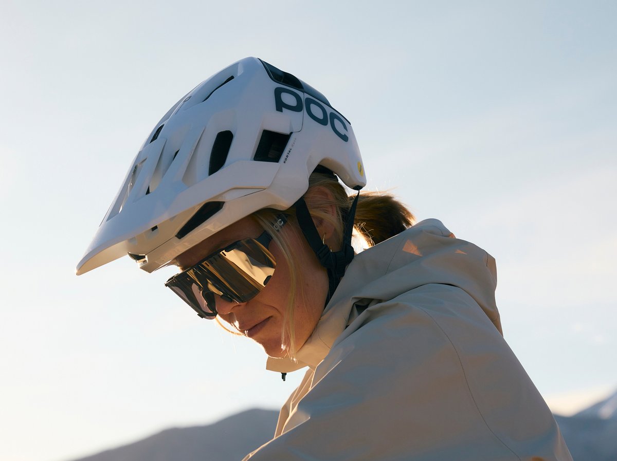 Mountain biker wearing a white POC helmet and sunglasses. Summit+ Club limited time offer.