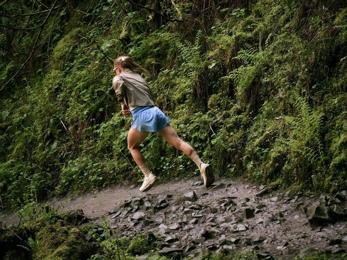 Runner on muddy trail wearing Altra shoes.