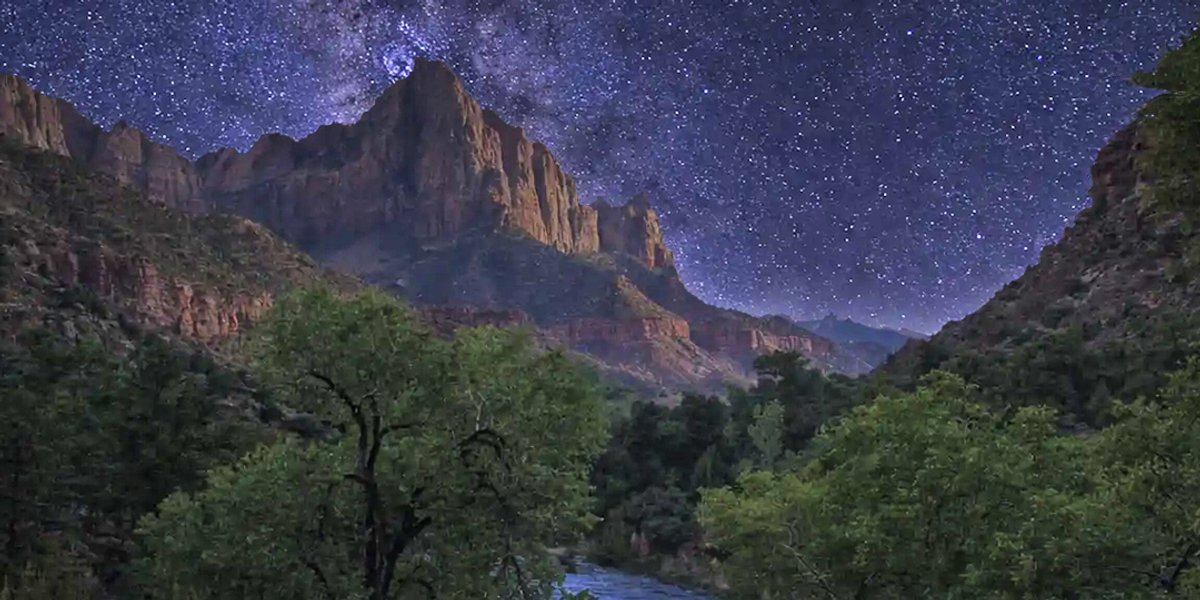 Zion canyon at night under a star-filled sky.