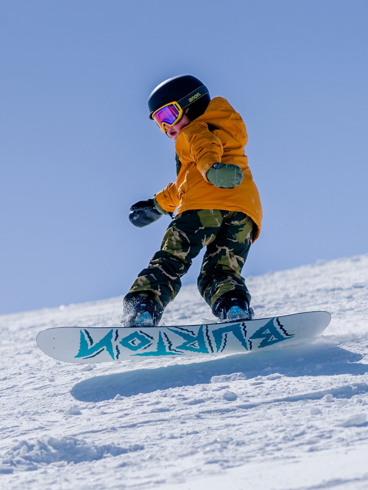A grom pops an ollie on his Burton board.