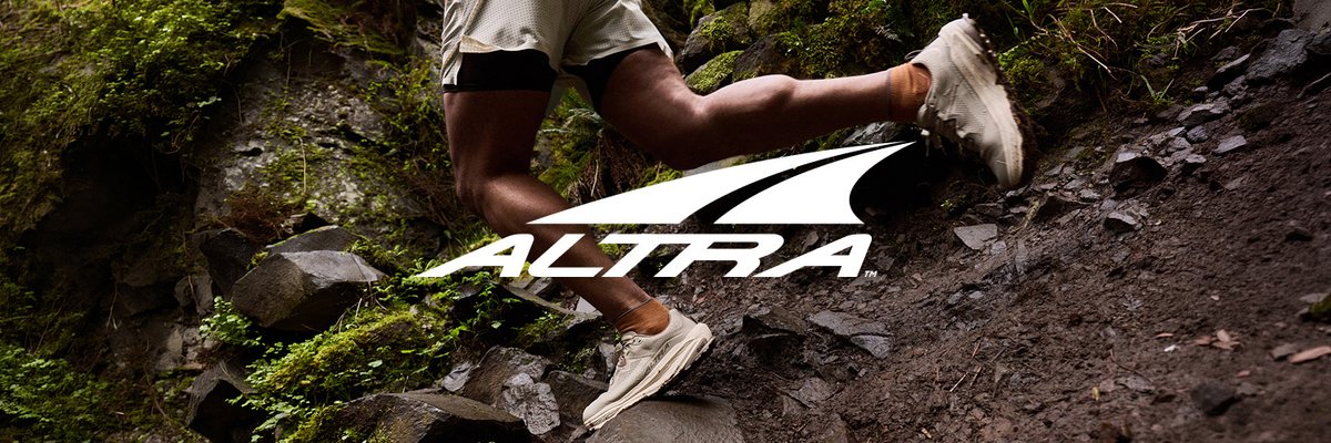 Trail runner navigating a mossy, rocky technical trail, featuring the Altra logo.