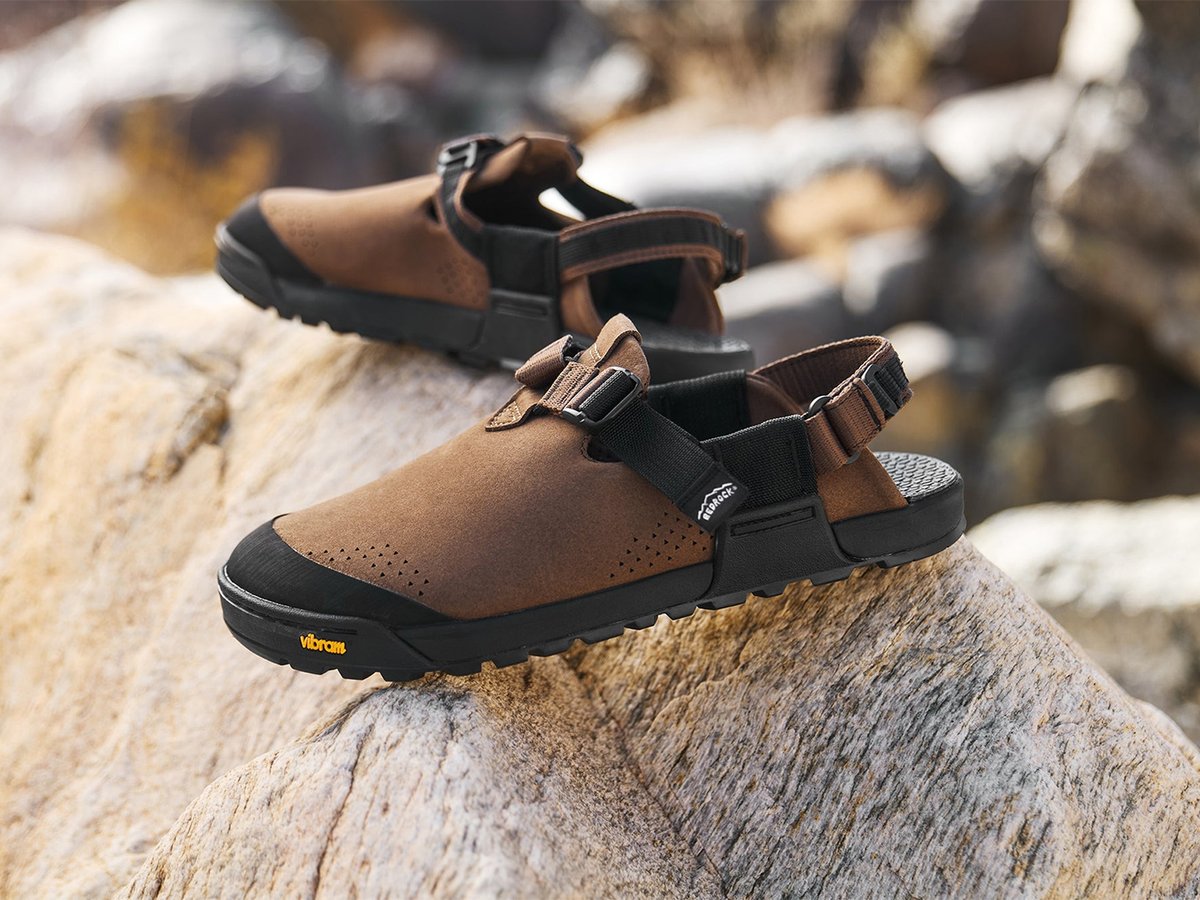 Two pairs of Bedrock Mountain Clogs in dark chocolate synthetic suede on rocky terrain