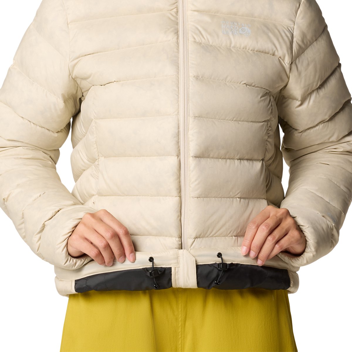A model wearing the Tiberondack Parka flips the hem upwards, revealing the drawcord waist detail. 