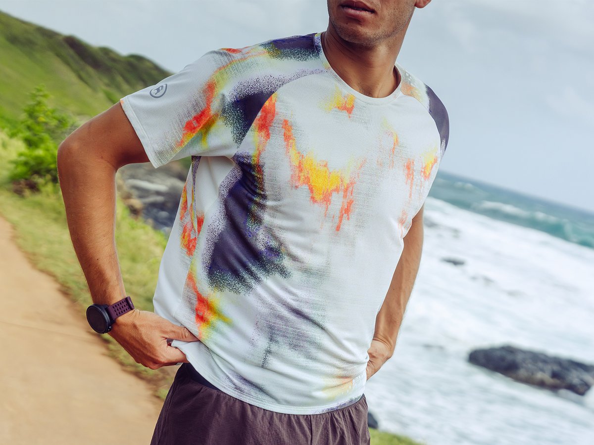 Person standing on oceanside overlook adjsuting their shirt.