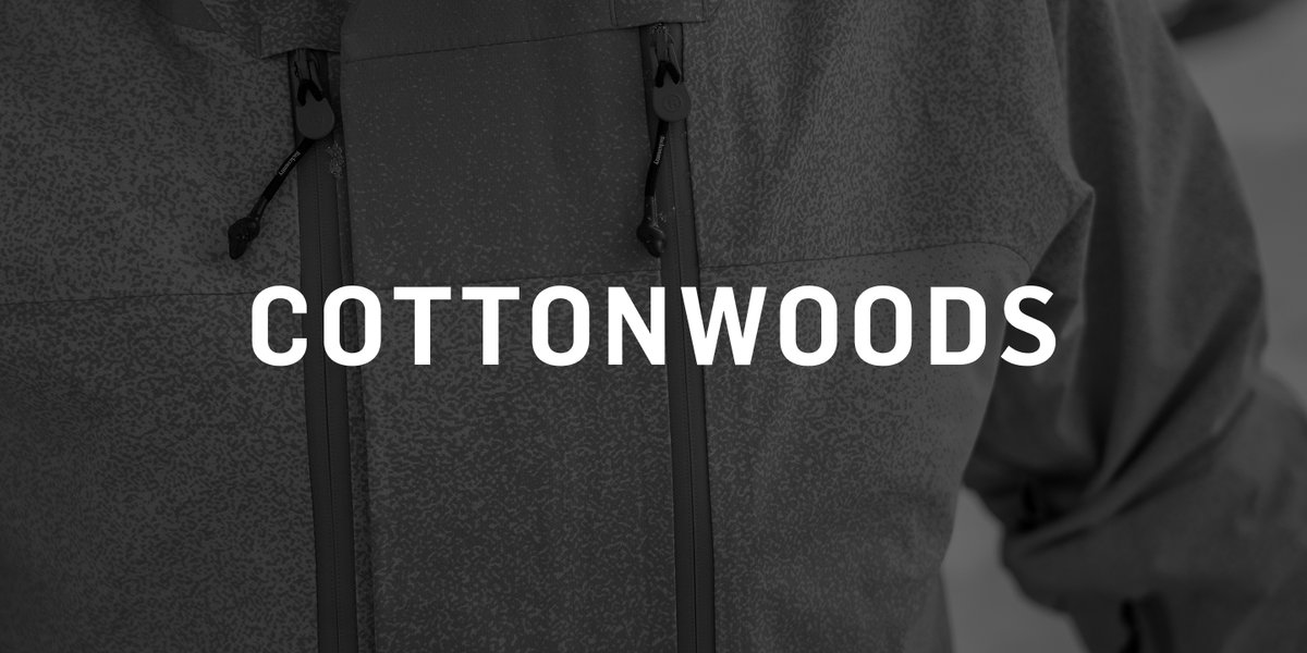 Close-up of the Cottonwoods jacket's chest, showing dual zippered pockets with black zipper pulls on dark textured fabric.