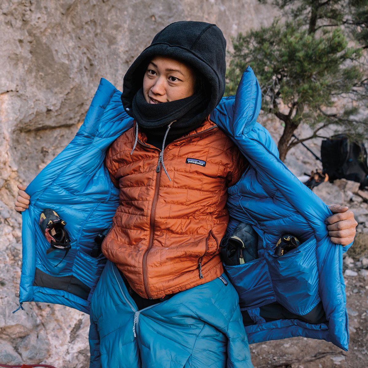 A woman pulls off her blue Patagonia puffy.
