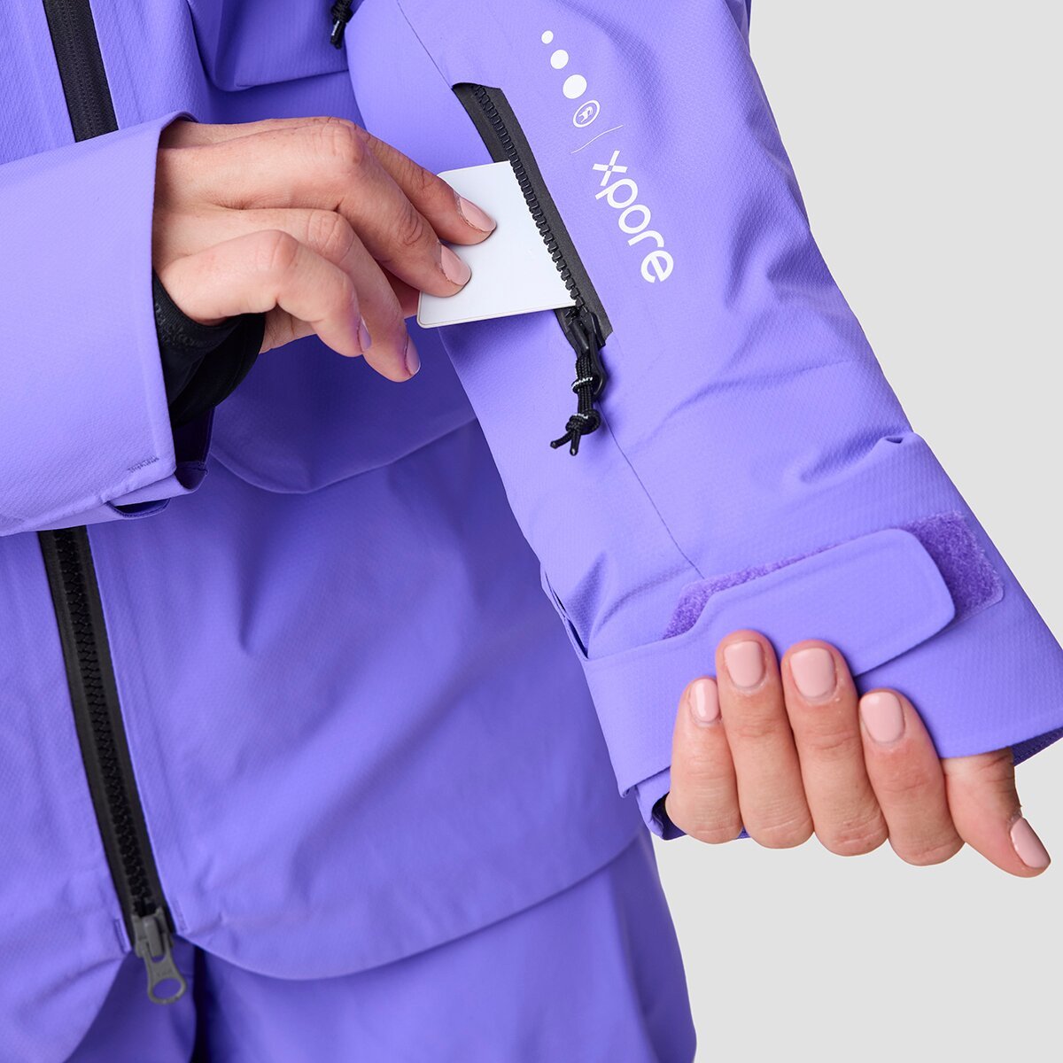 Person removing ski pass from zippered sleeve pass pocket.