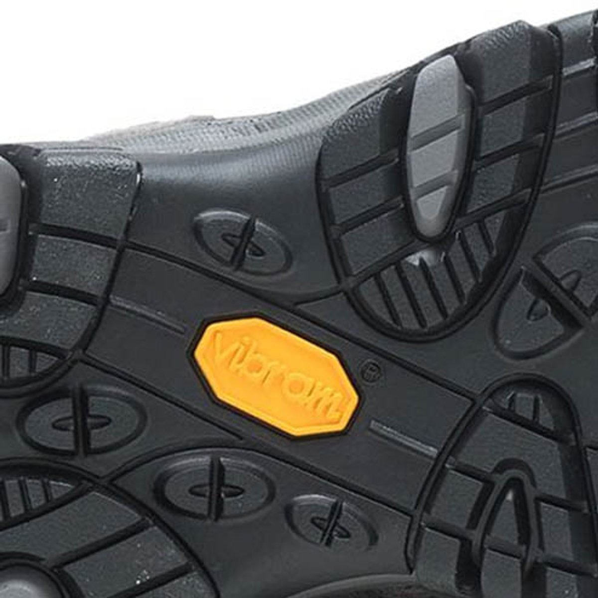Bottom view of a hiking boot outsole showing multidirectional lug pattern and Vibram branding badge.