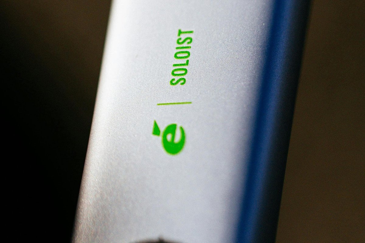 Close-up of Cervélo Soloist carbon road bike frame showing model name and logo badge in green on silver and blue frame