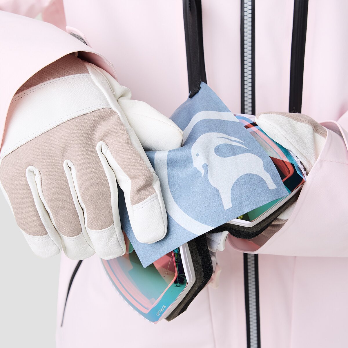 Person wearing Cottonwoods ski jacket and gloves using integrated lens wipe on a pair of goggles.