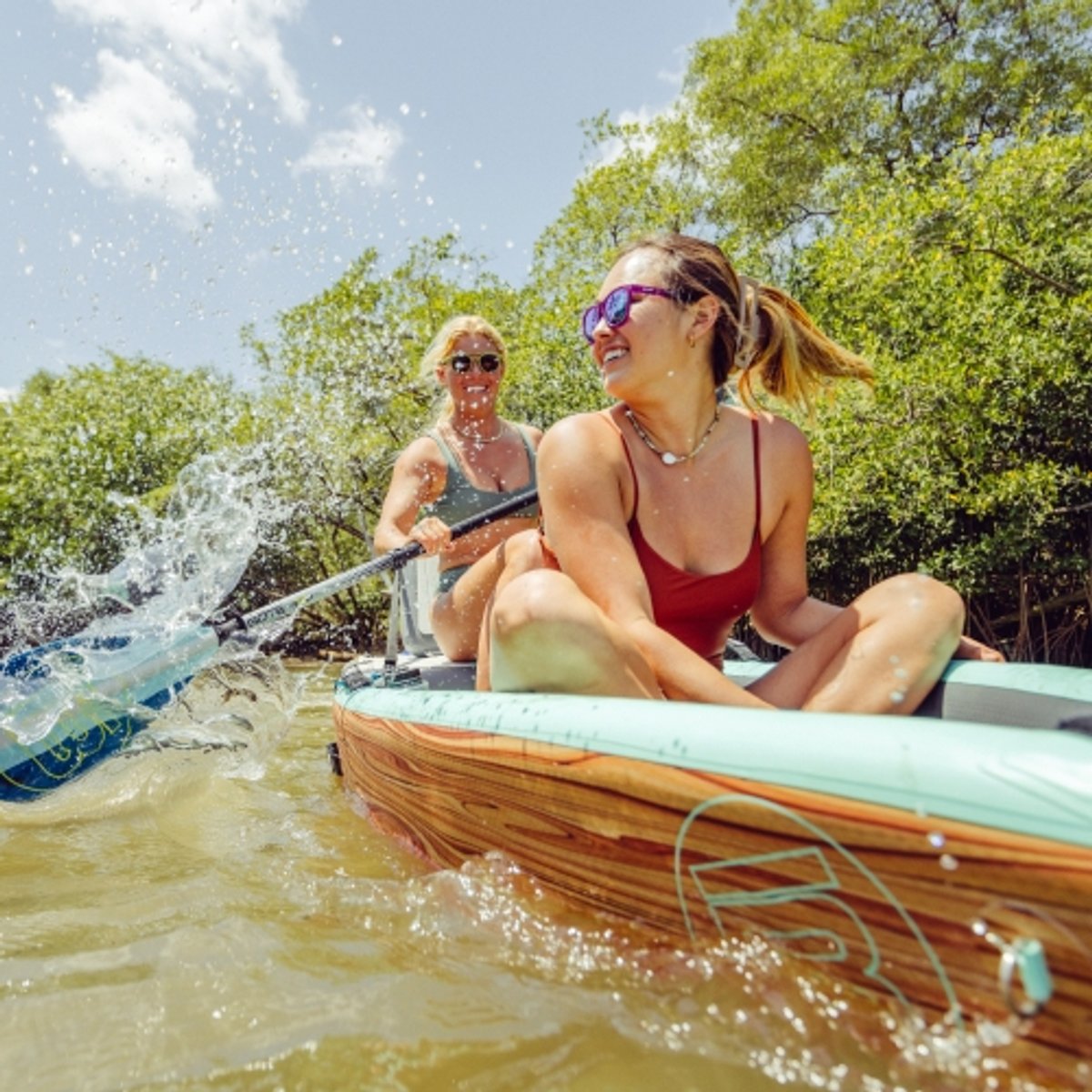 Two kayakers paddle their way across the open water. 