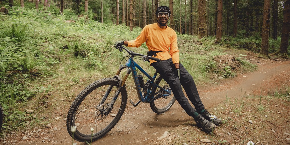 Mountain biker leaning against his bike on the trail.