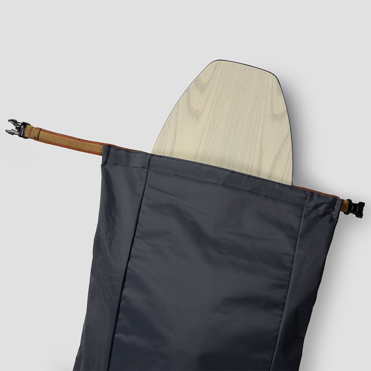 Ski bag roll top closur with reinforced webbing and clip buckle with a snowboard sticking out the top.