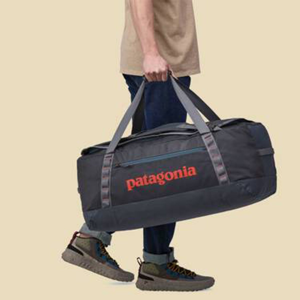 A person walking while carrying the Black Hole Duffel 70L