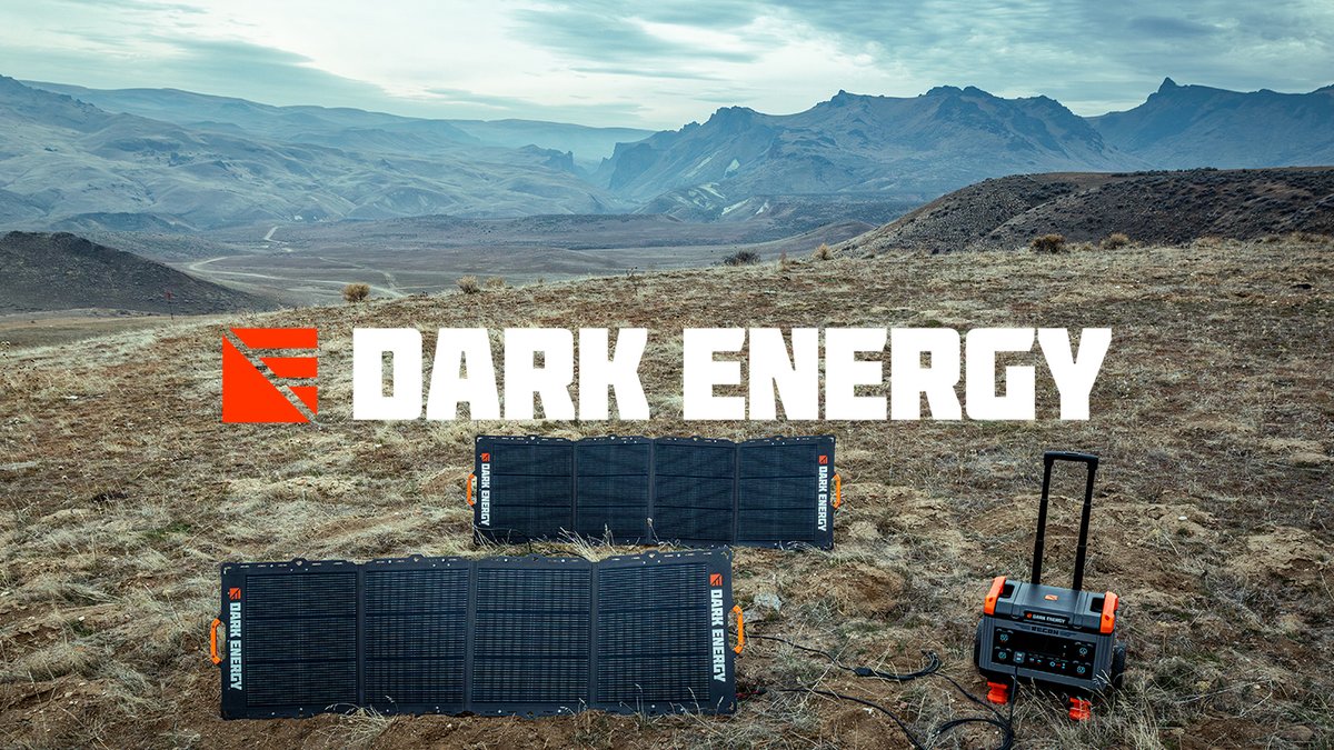 Two Dark Energy Spectre folding solar panels and a Recon 2000 power station set up on a dry grass hillside above a wide desert valley, with the Dark Energy logo centered over the scene.