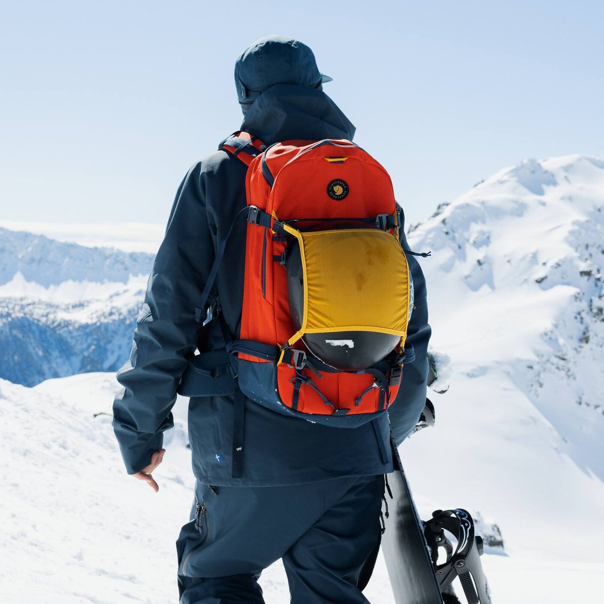 A person walking away shows off their brightly colored backpack.