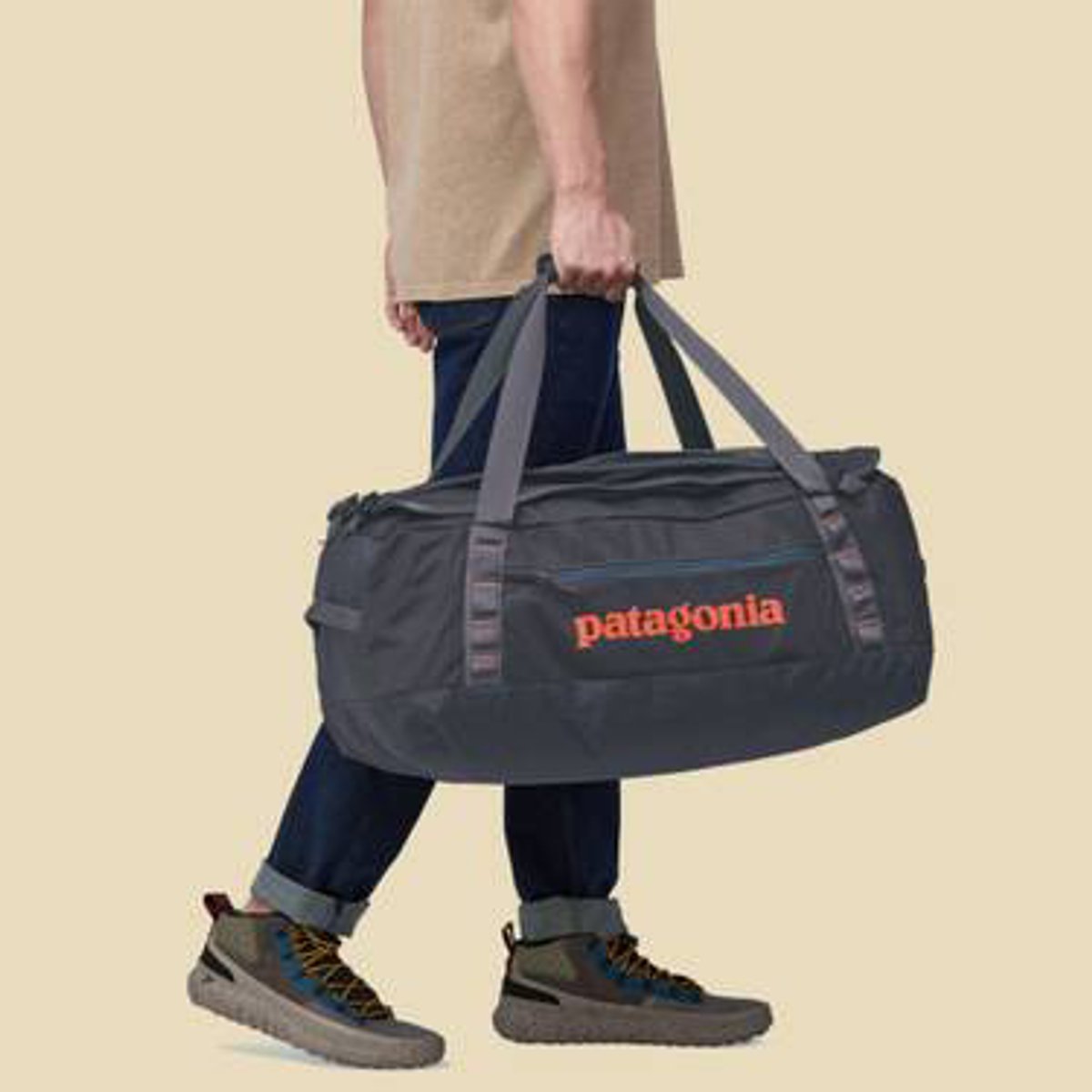 A person walking while carrying a Black Hole Duffel 55L