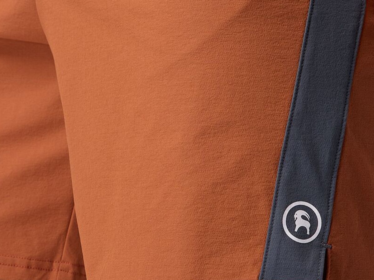 Close-up of pant leg material with stitched logo detail.