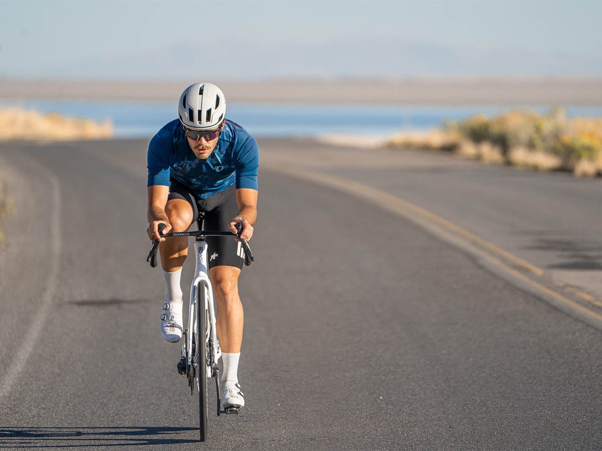 Cyclist riding the ENVE SES 6.7 PRO wheelset on an open road beside a salt flat and distant mountains.
