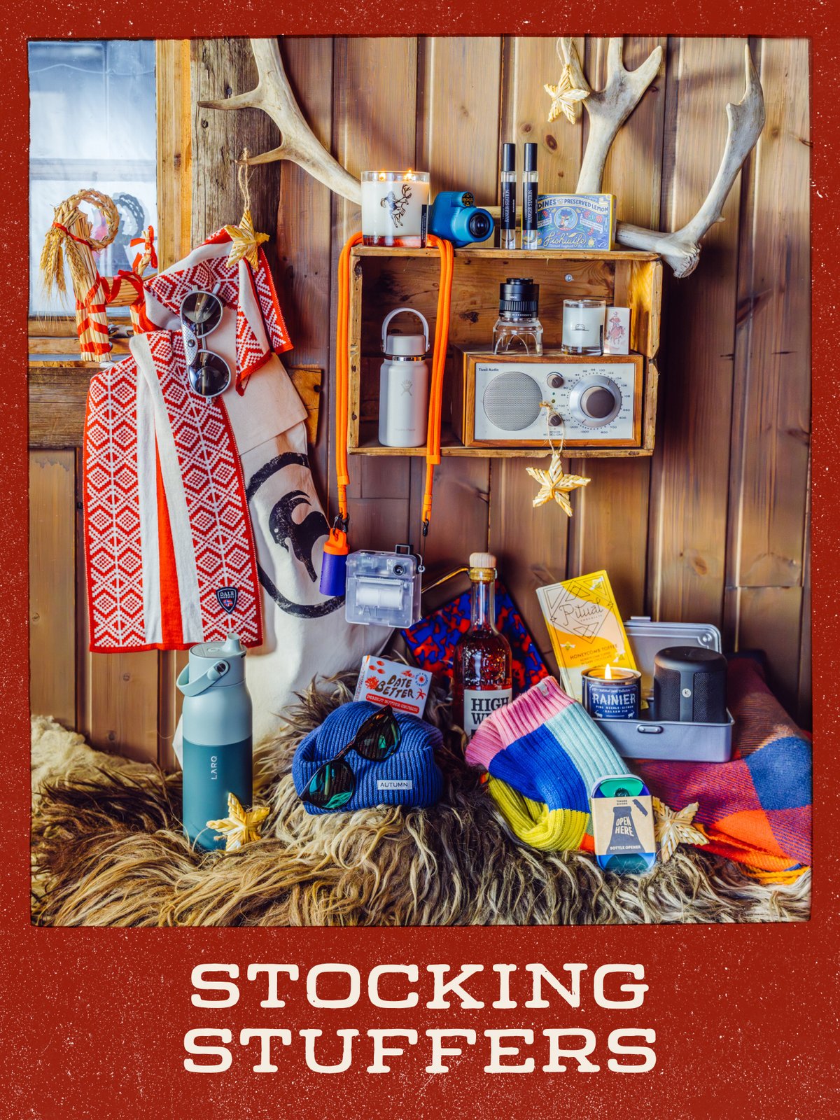 Holiday gift display of small gifts, including a radio, candles, water bottles, a beanie, and sunglasses, in a rustic cabin: “Stocking Stuffers.”