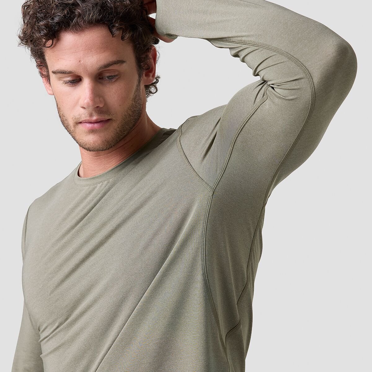 Personwearing Backcountry Tahoe Pro LT sun shirt with arm raised showing long and underarm gusset.