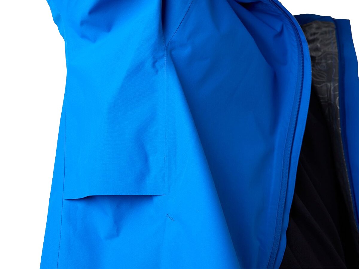 Close-up of blue waterproof jacket interior showing taped seams, drop pocket, and insulated liner construction detail