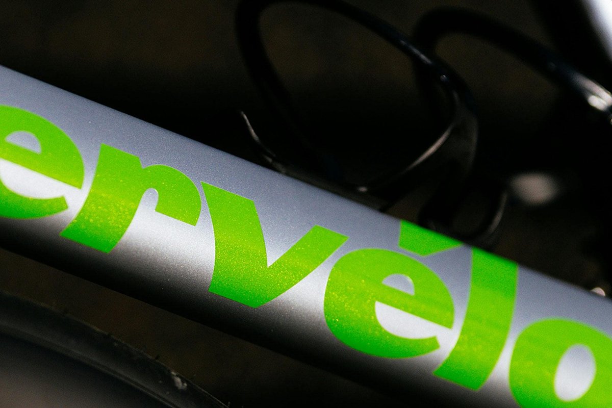 Close-up of Cervélo carbon road bike frame tube with high-contrast green lettering detail against dark background